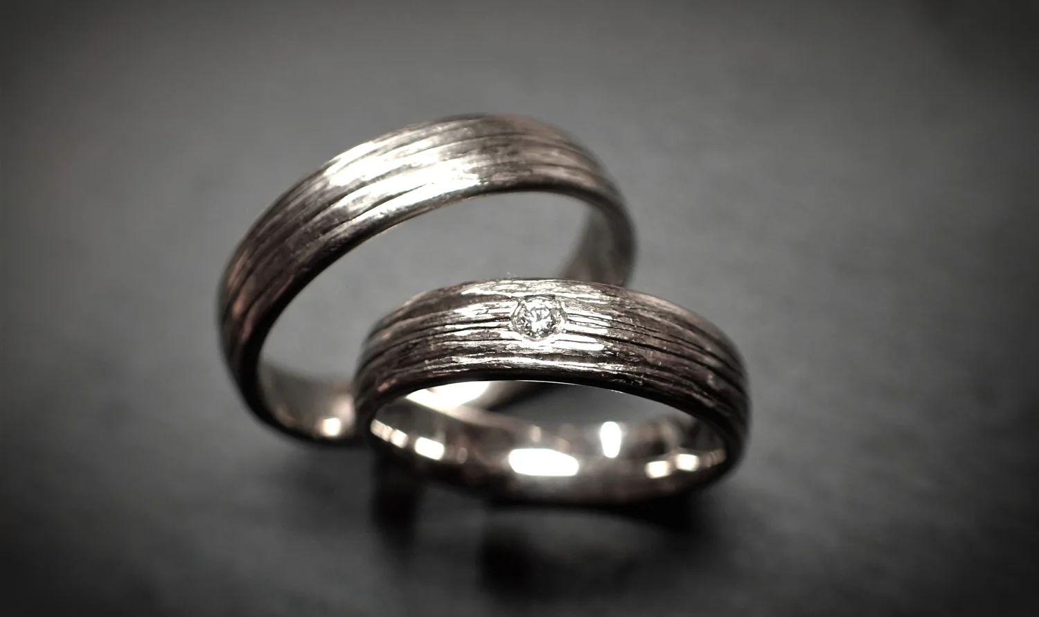 Ein Paar Weißgold Trauringe 585/- mit längsstruktur und einem Brillanten im Damenring von Solitaire Lechler Freiburg