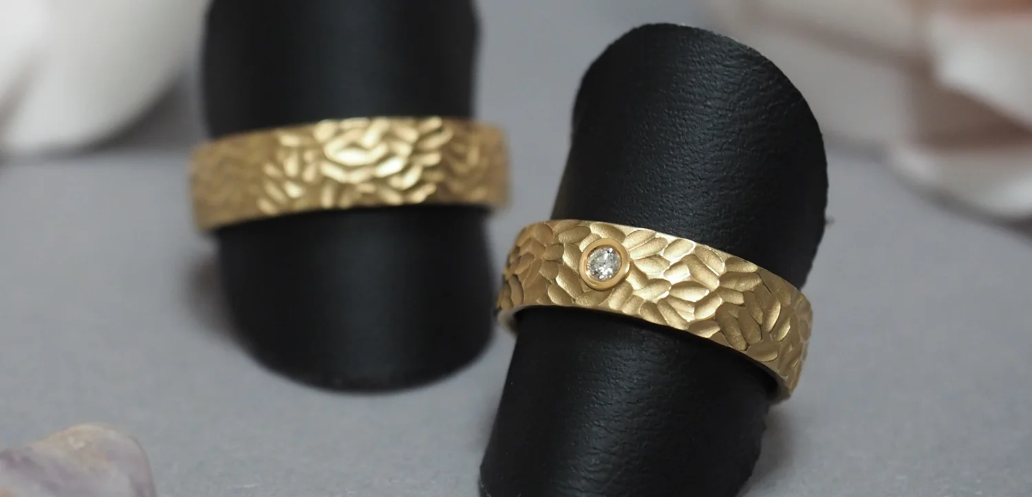 Ein Paar strukturierte Trauringe Gelbgold 585/-, Damenring mit einem lupenreinen Brillanten