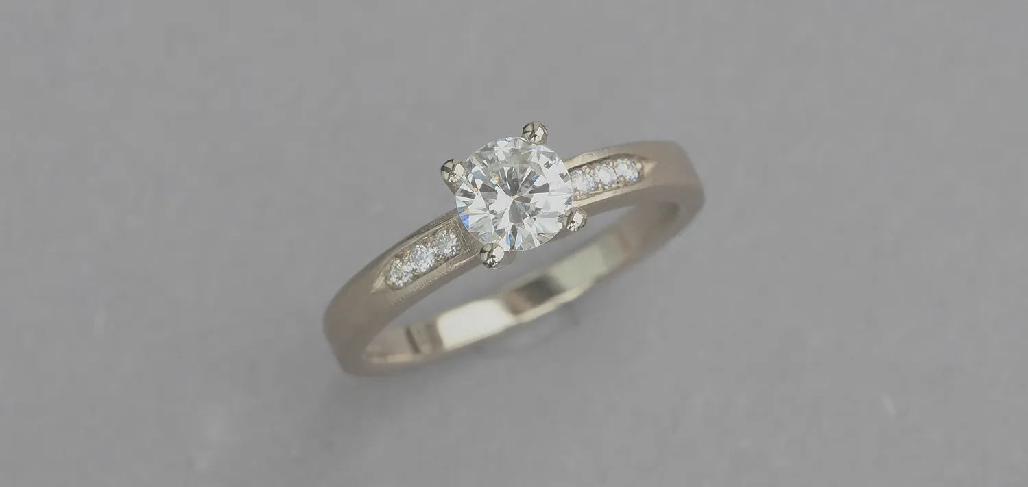 Verlobungsring aus Weißgold 585/- mit einem Brillant 0,25 carat und seitlich sechs lupenreine Brillanten im Verschnitt gefasst