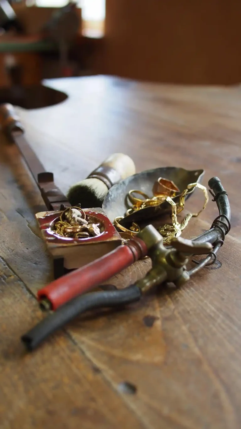 Altgold und Schmelztiegel auf einem Goldschmiedetisch