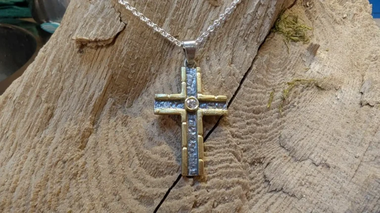 Ein Kreuz als Freiburger Bächlemotiv in Silber mit Gold und einem Brillanten